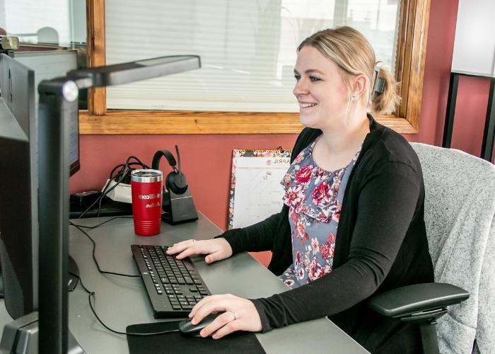 Woman sitting at computer desk.